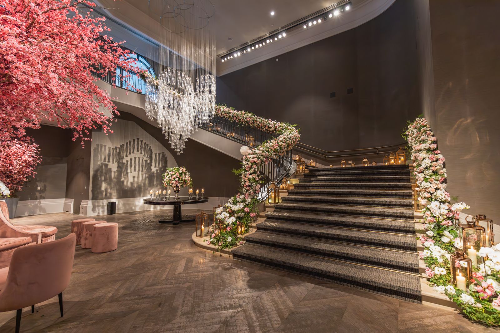 Opulent indoor staircase decorated with flowers and chandelier