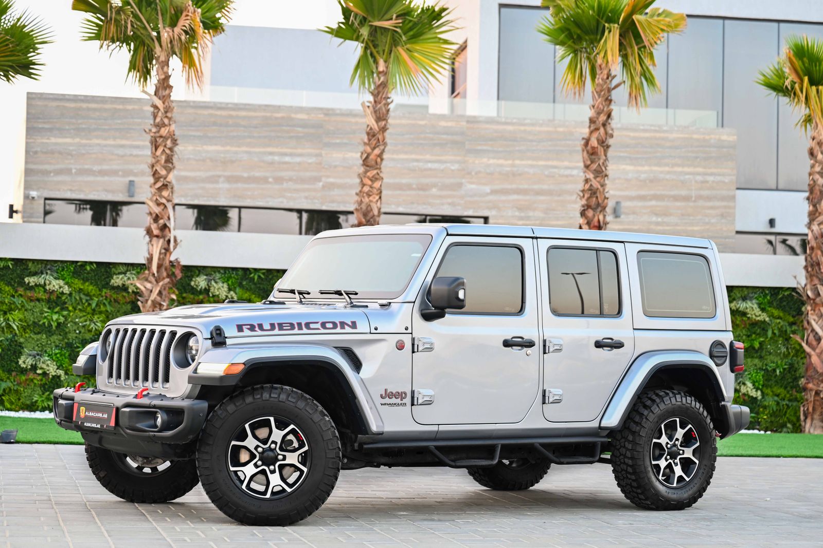 Silver Jeep Wrangler Rubicon parked in a modern setting