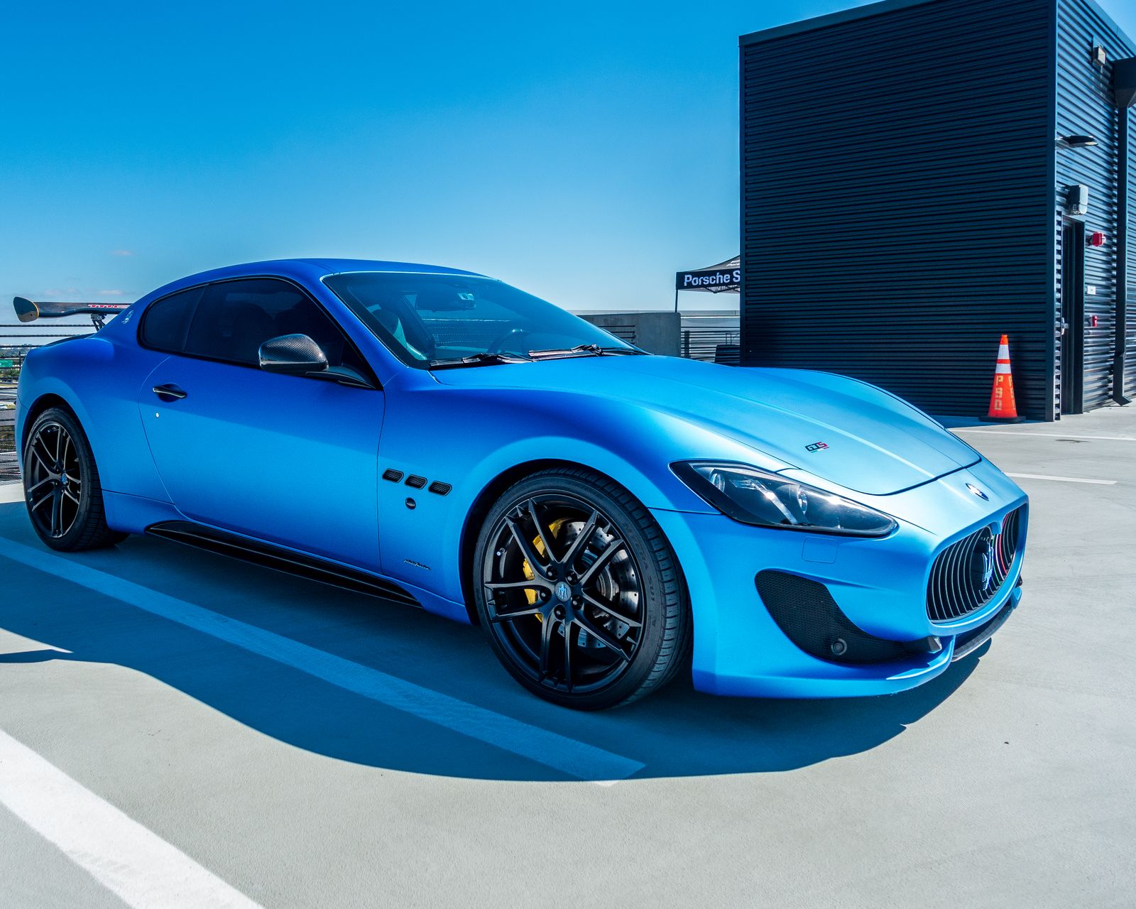 Blue Maserati sports car at a modern garage