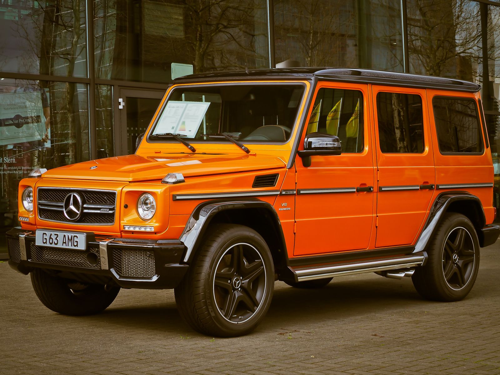 Orange Mercedes-Benz G Wagon parked in front of a building