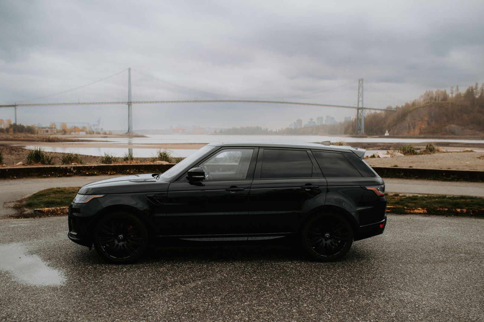 Black Range Rover parked near a bridge