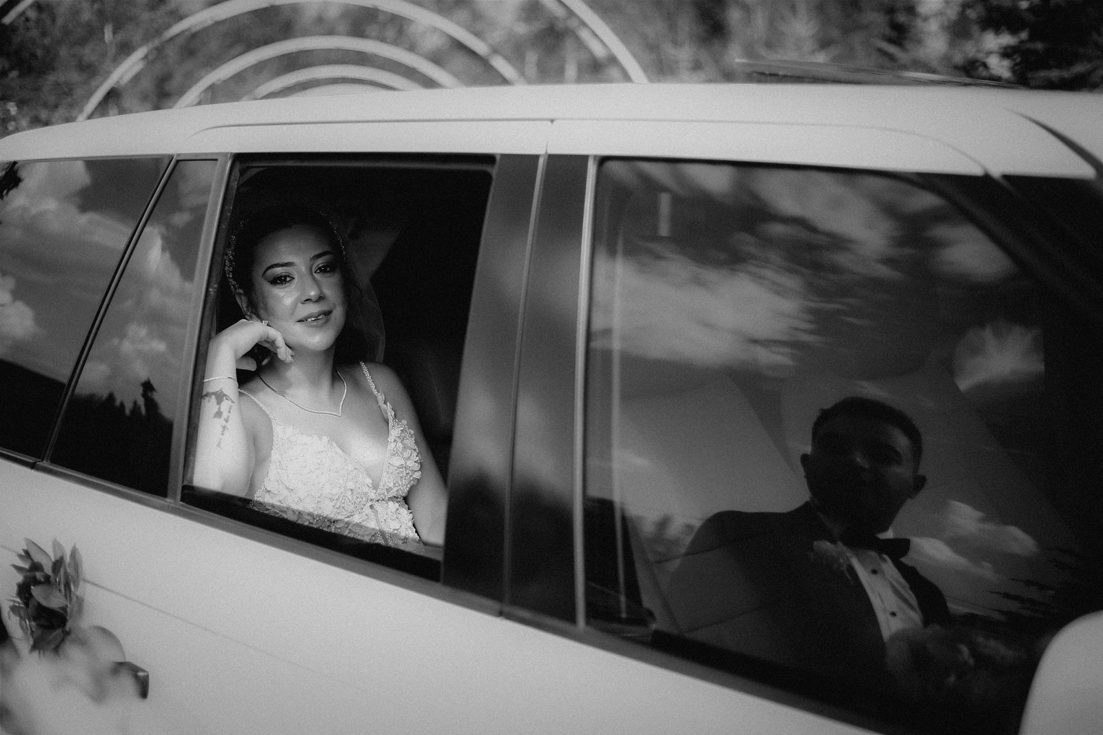 Elegant black and white photo of newlyweds in a car